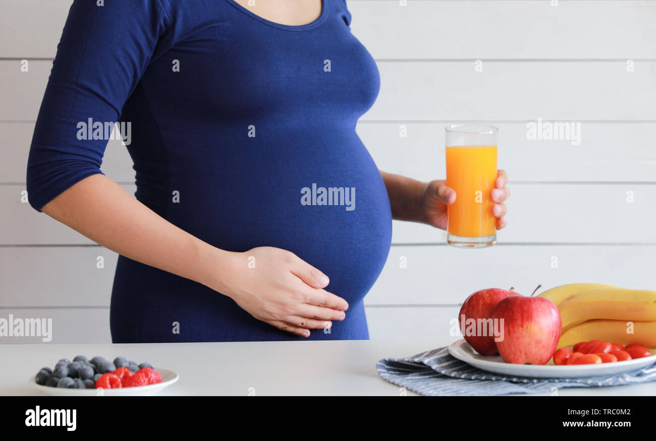 Pregnant woman drink orange fruit juice, healthy Stock Photo