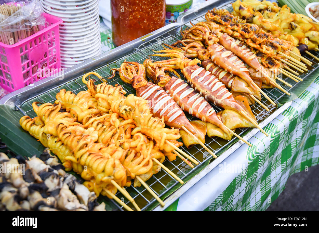 Grilled squid skewer sticks on grill for sale in the street food market