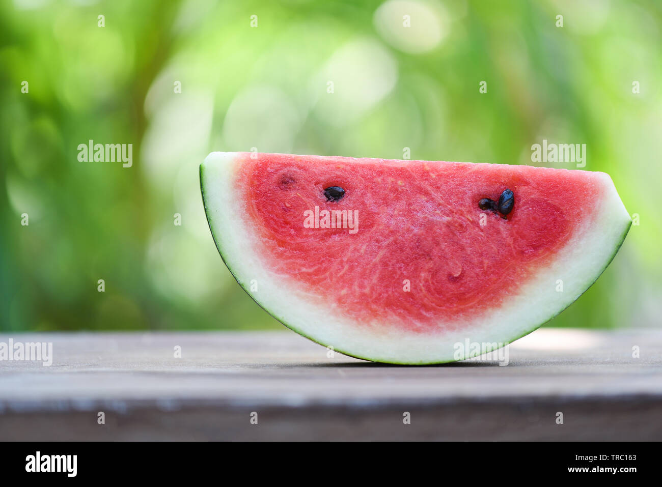 slice watermelon fruit on nature green blur background Stock Photo - Alamy