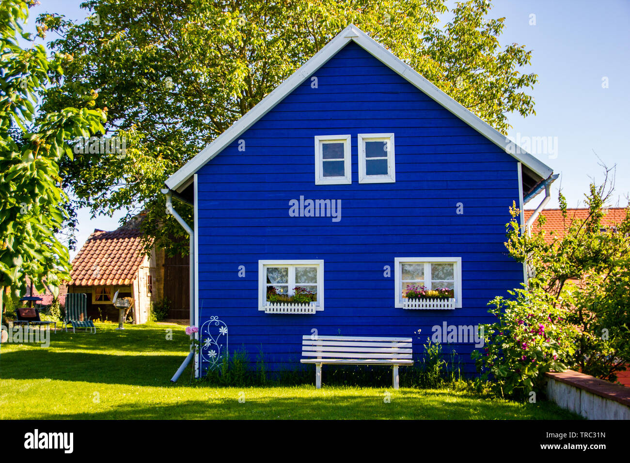 Unidentified big blue painted garden house in the Scandinavian building style made out of wood Stock Photo