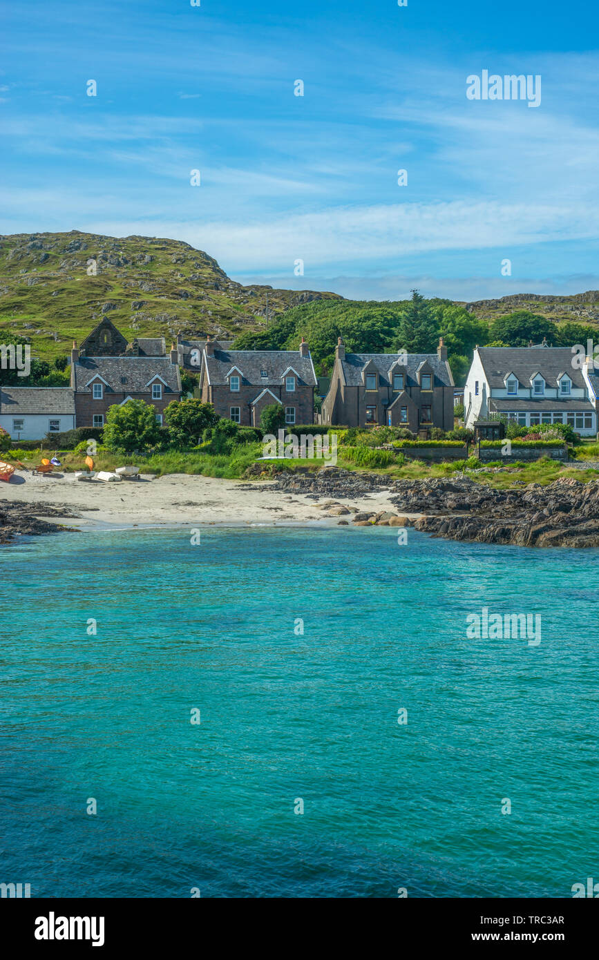 Traditional Village Beside Turquoise Sea and White Sand Beach in the Hebrides Islands in Scotland Stock Photo