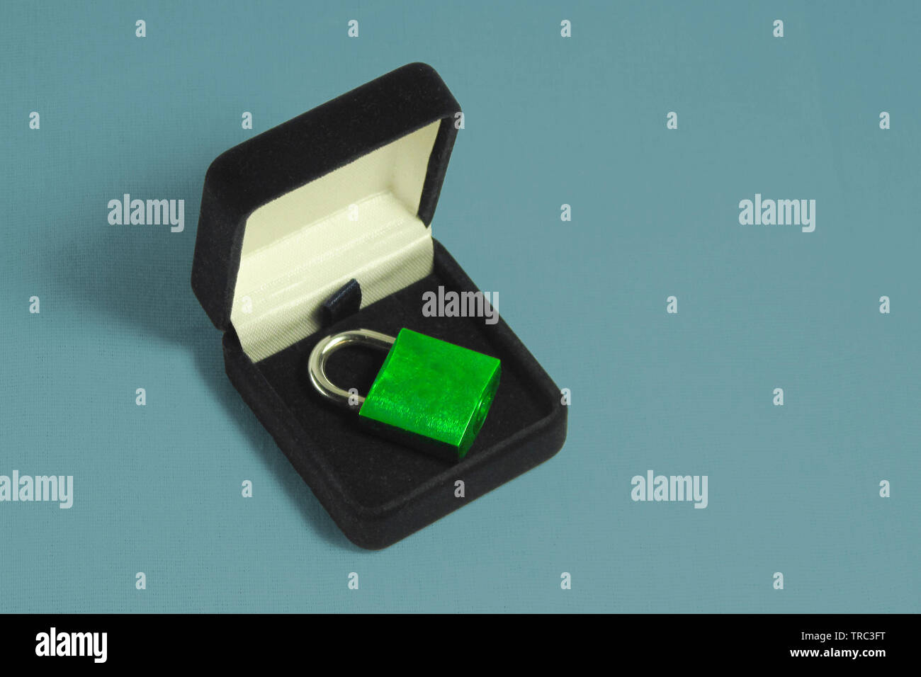 Lock in gift box. Green padlock with closed shackle in jewelry chest