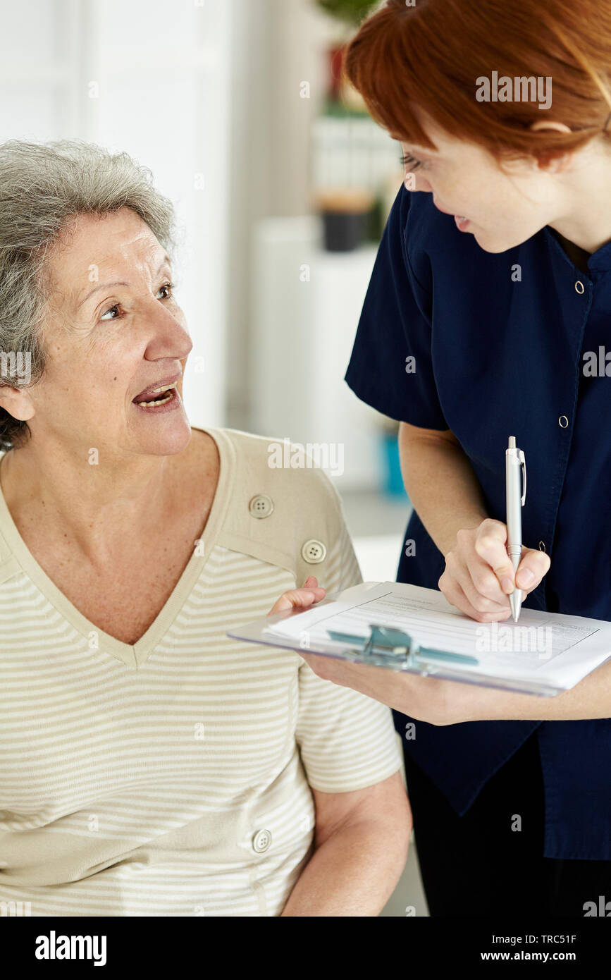 Nurse writing medical history of patient Stock Photo