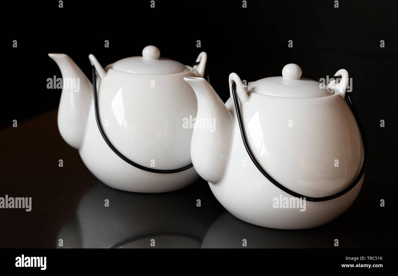 White kettles or tea pots on black background Stock Photo
