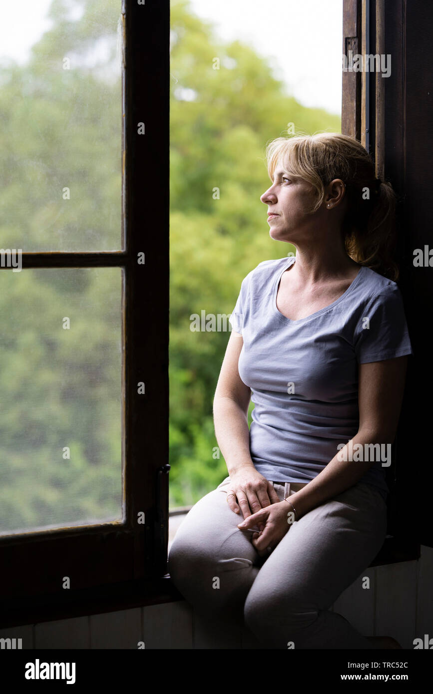 Thoughtful woman sitting on hi-res stock photography and images - Alamy