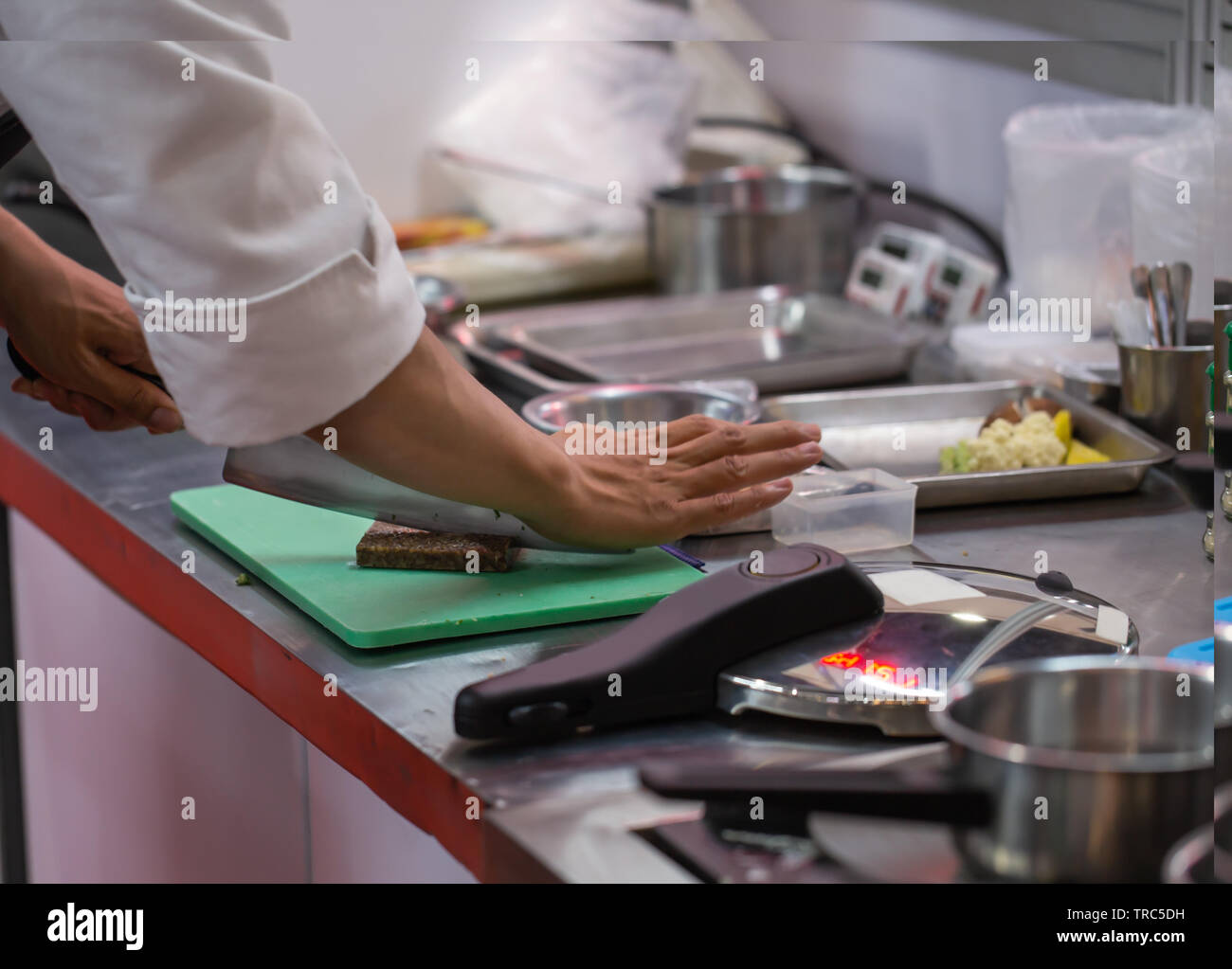Chef cutting food in a plastic cutting board Stock Photo