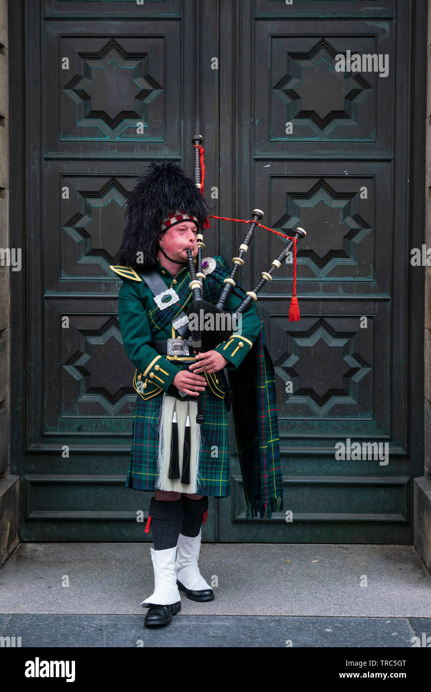 Scottish piper playing bagpipes on Royal Mile outside Edinburgh High Court in Edinburgh Old Town, Scotland ,UK Stock Photo
