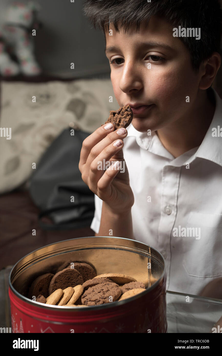 Boy, 11 years old eats chocolate cookie Stock Photo
