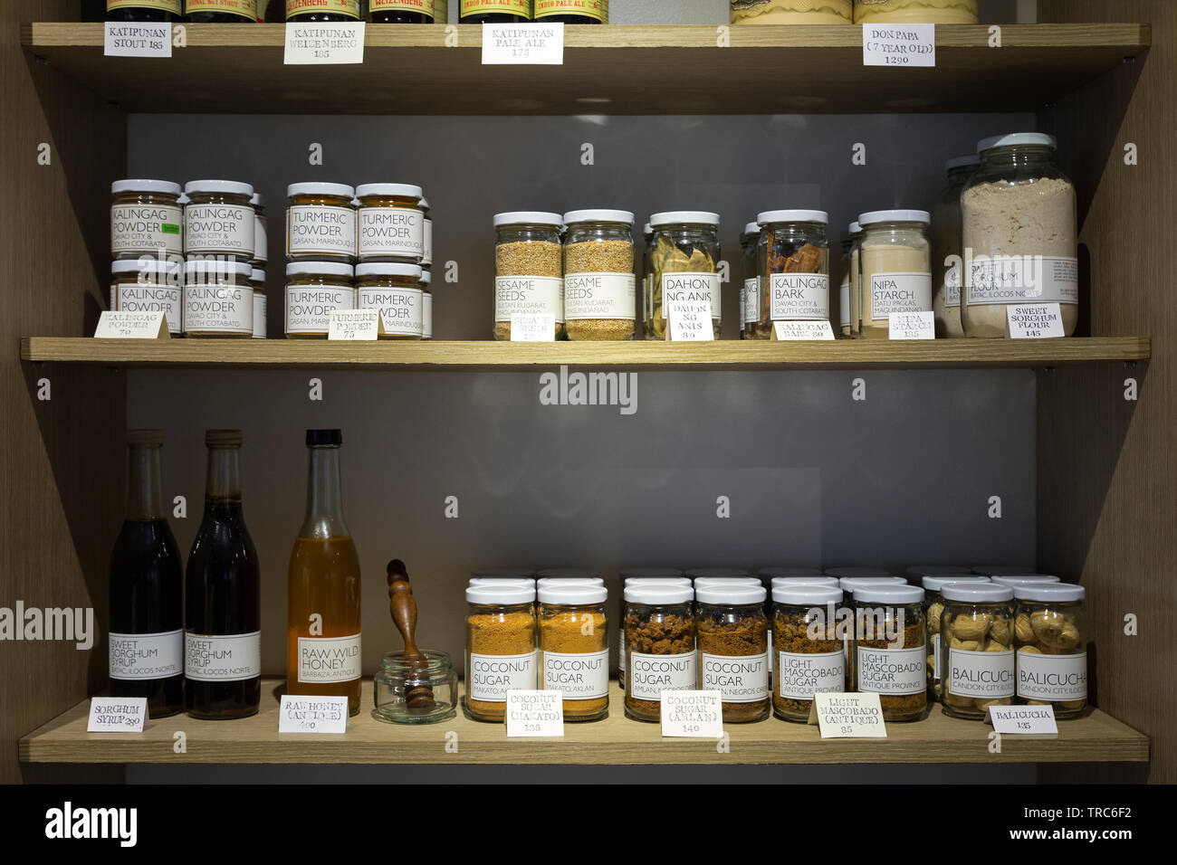 Manila, Philippines - August, 4, 2016: Wooden shelves in a shop full of jars and bottles with natural organic products Stock Photo