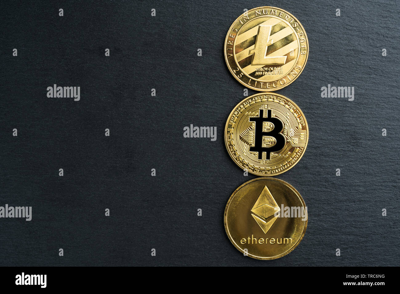 Physical Bitcoin, Litecoin and Ethereum gold coins on a black stone slate  plate background. Cryptocurrency. Copy space on the left Stock Photo - Alamy