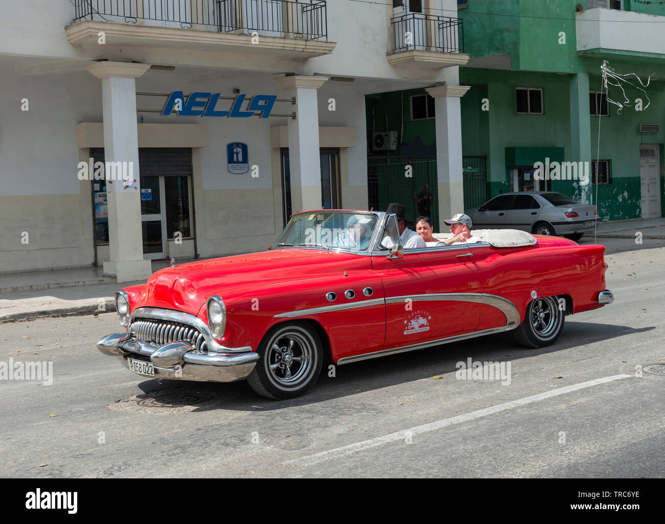 Classic American 1950's red car driving tourists around the town of Havana,  Cuba, Caribbean Stock Photo