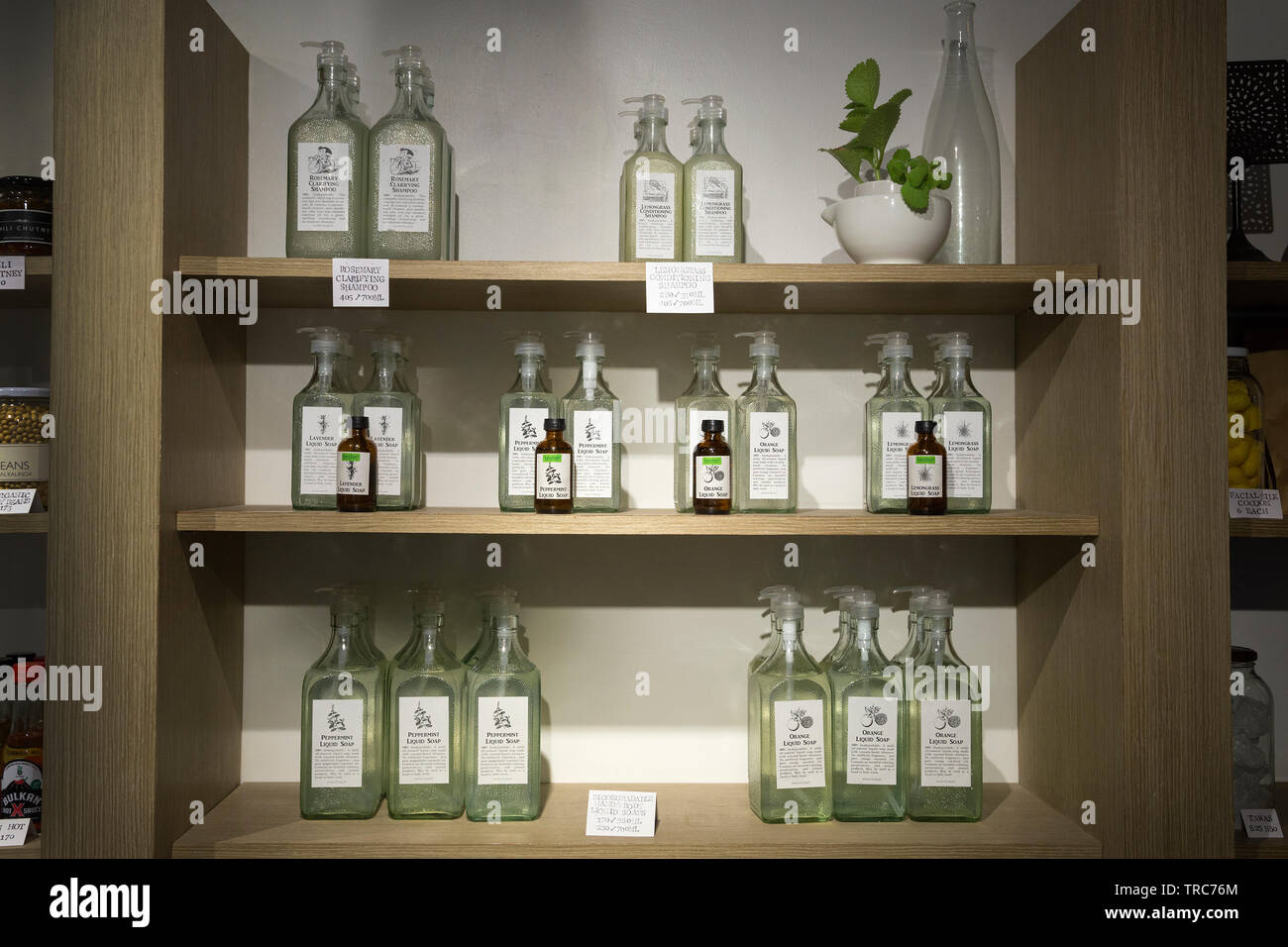 Manila, Philippines - August, 4, 2016: Wooden shelves in a shop with glass bottles Stock Photo