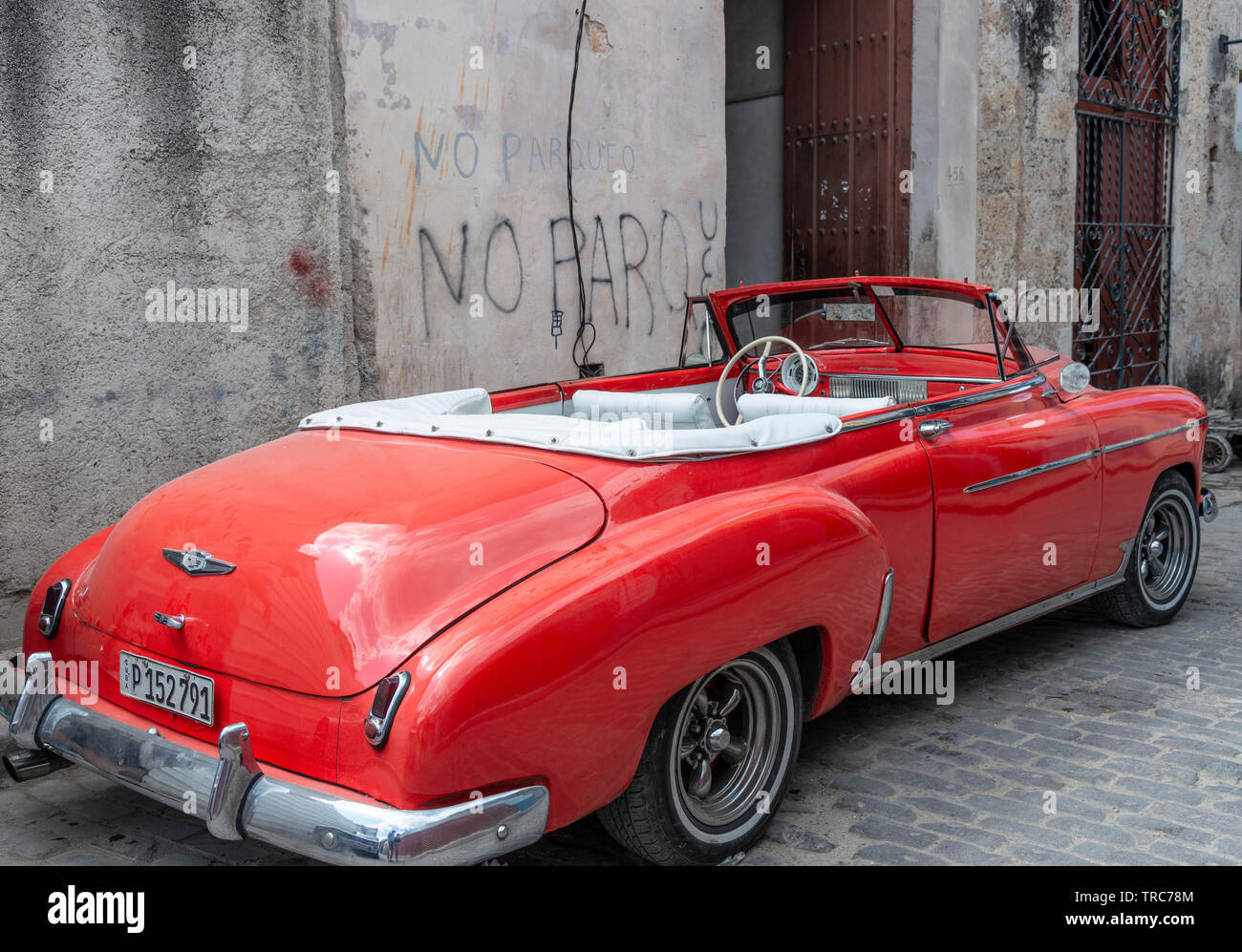Classic American 1950's red car parked up beside a no parking sign on one of the streets in the Old Town  of Havana (Habana Vieja)  Cuba, Caribbean Stock Photo