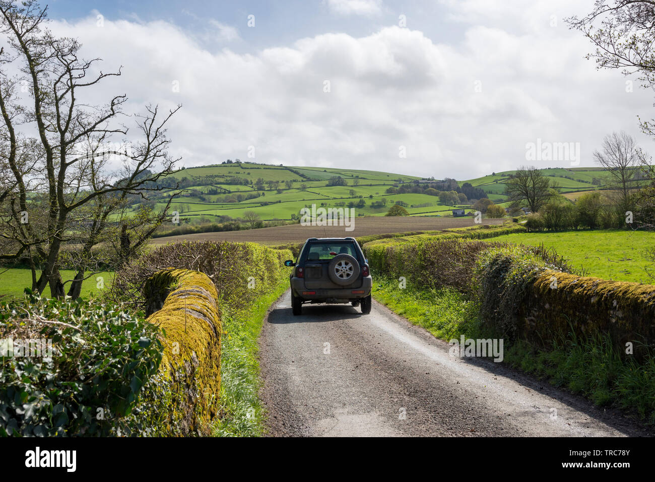 Car on a country lane near Clun in the Shropshire countryside on a beautiful sunny spring day. Stock Photo