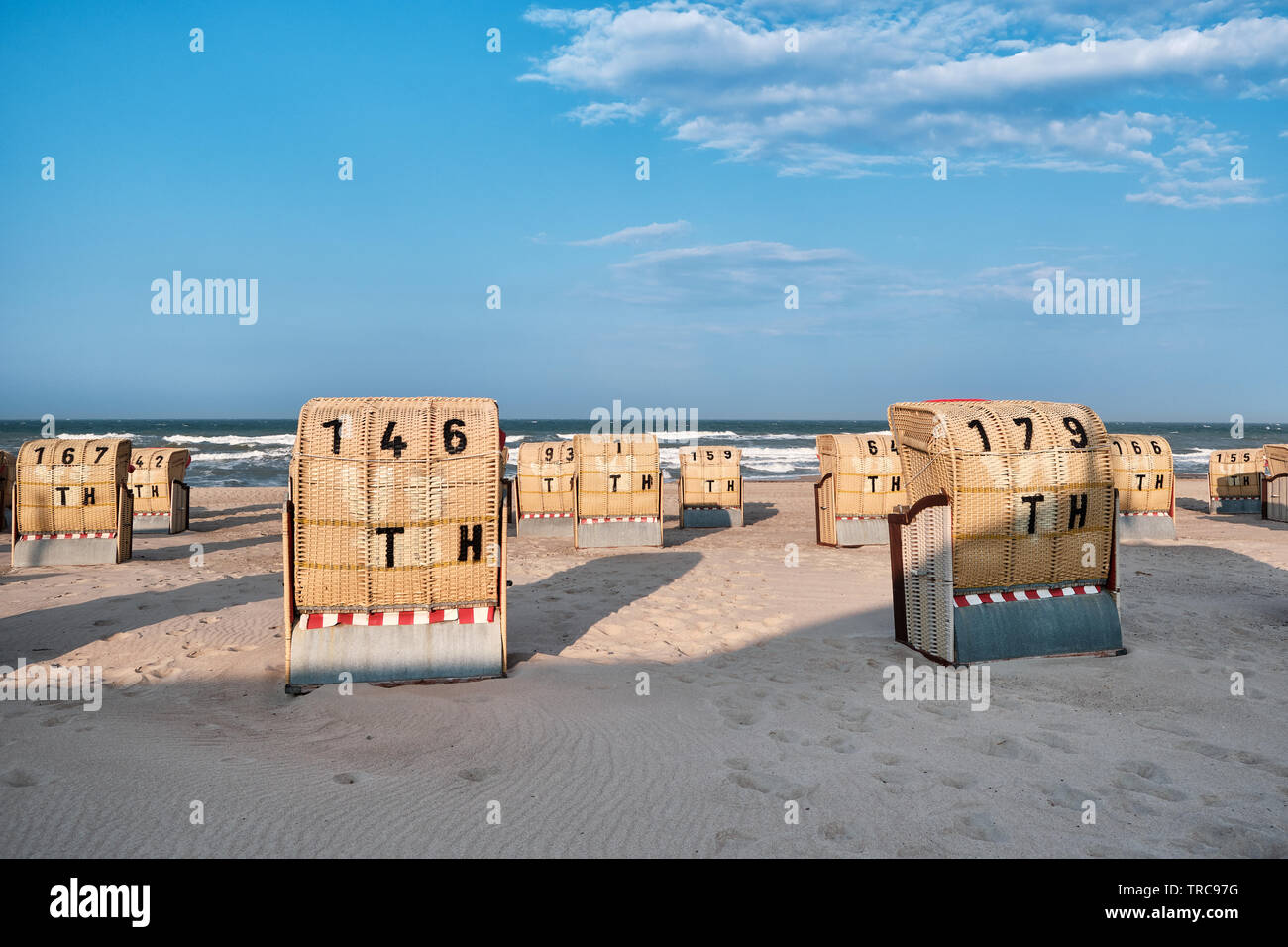 View from a beach onto the Baltic Sea and the backsides of empty beach chairs at sunset Stock Photo