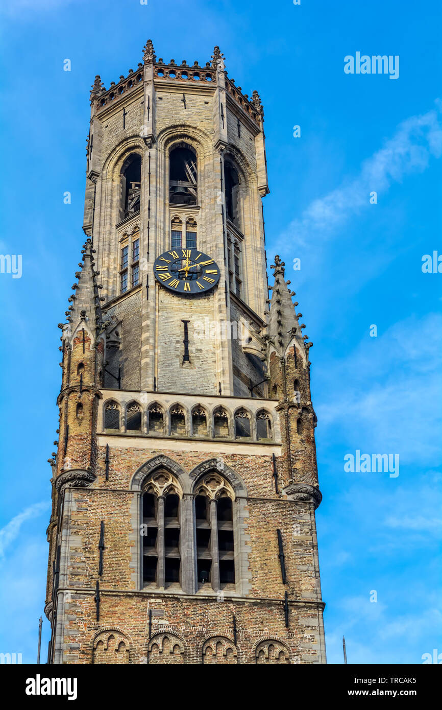 Belfry of Bruges, the medieval bell tower against blue sky. The 83 meter high belfry or hallstower (halletoren) is Bruges' most well-known landmark Stock Photo