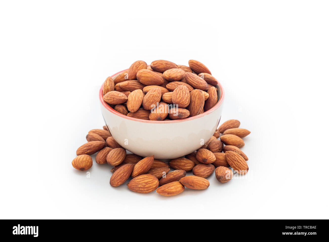 Heap almonds in cup on white background Stock Photo