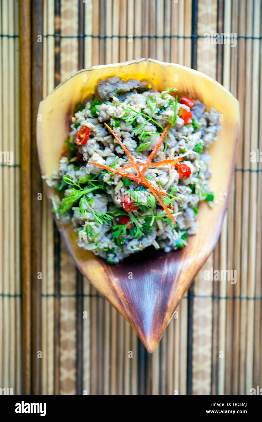 Saa moo, minced pork tossed with the diced heart of the banana flower, shallot and mint, at 3 Nagas Restaurant in Luang Prabang, Laos. Stock Photo