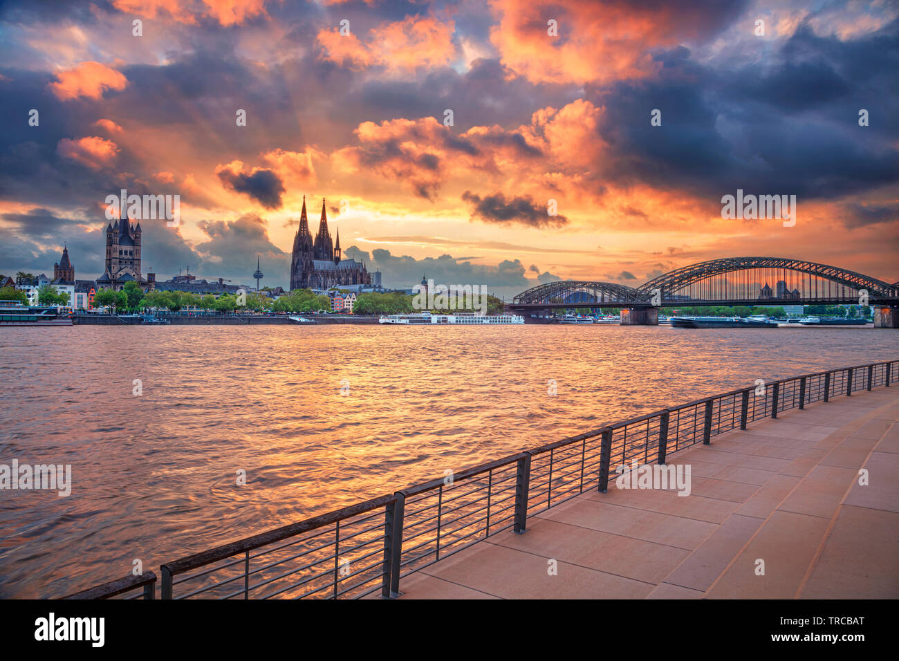Cologne, Germany. Cityscape image of Cologne, Germany with Cologne Cathedral and Hohenzollern Bridge during dramatic sunset. Stock Photo