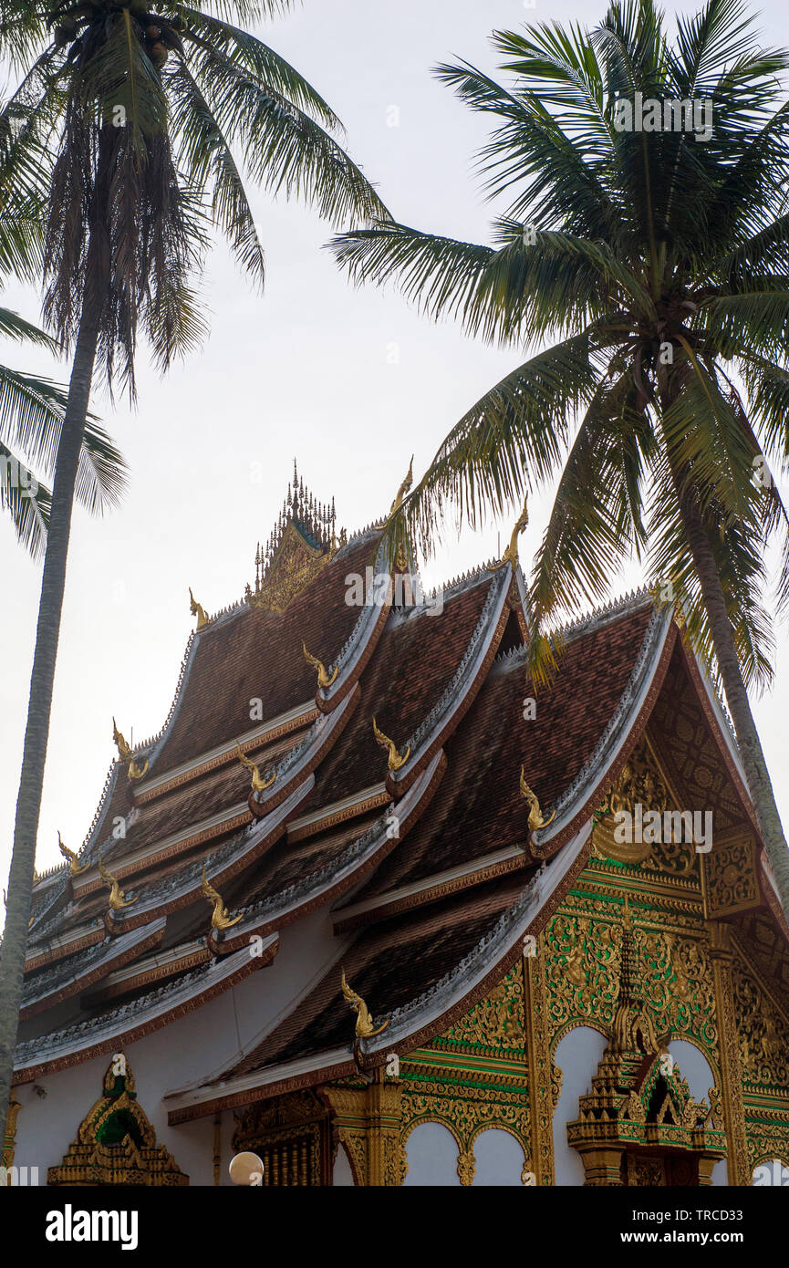 Palm trees flank Haw Pha Bang temple in central Luang Prabang. The former royal capital has World Heritage listing for it's Buddhist temples. Laos PDR Stock Photo
