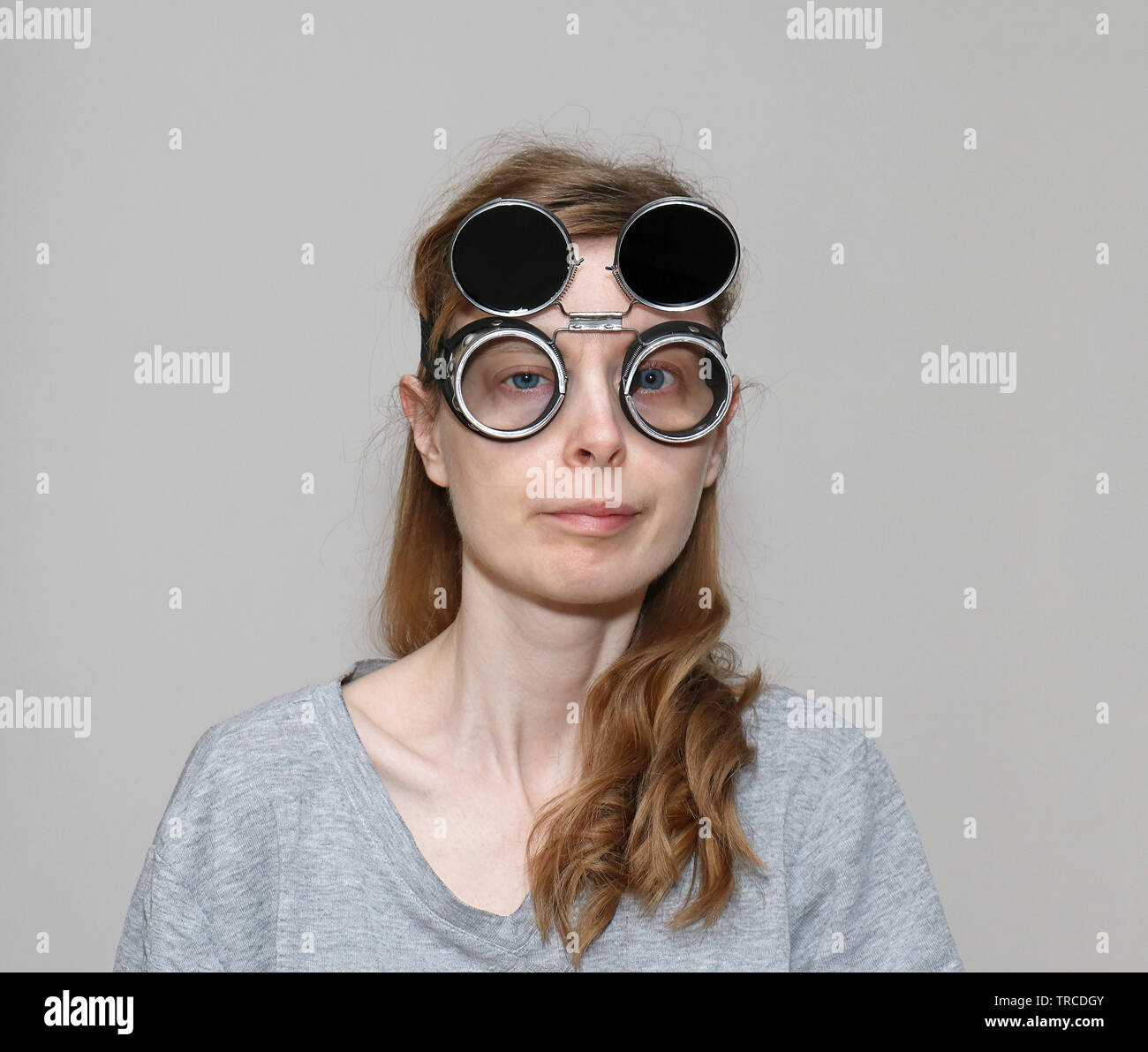 Cross eyed girl with dark welding glasses on her head Stock Photo