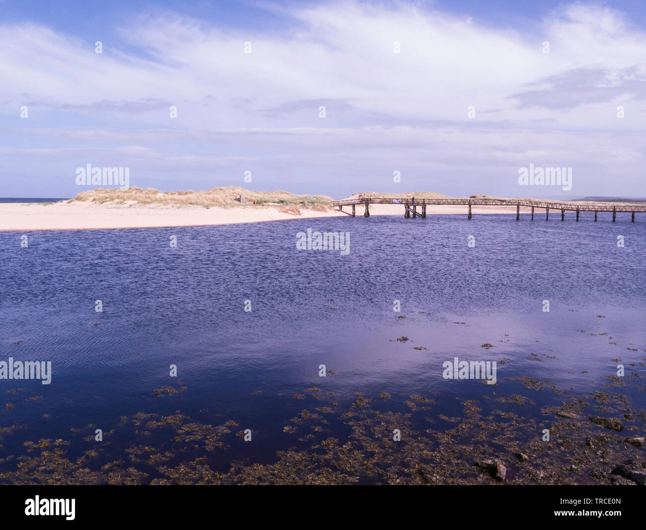 Lossiemouth sea front with long sandy beach accessed by bridge from promenade Moray Speyside Northern Scottish Highlands on Moray Coast Trail Stock Photo