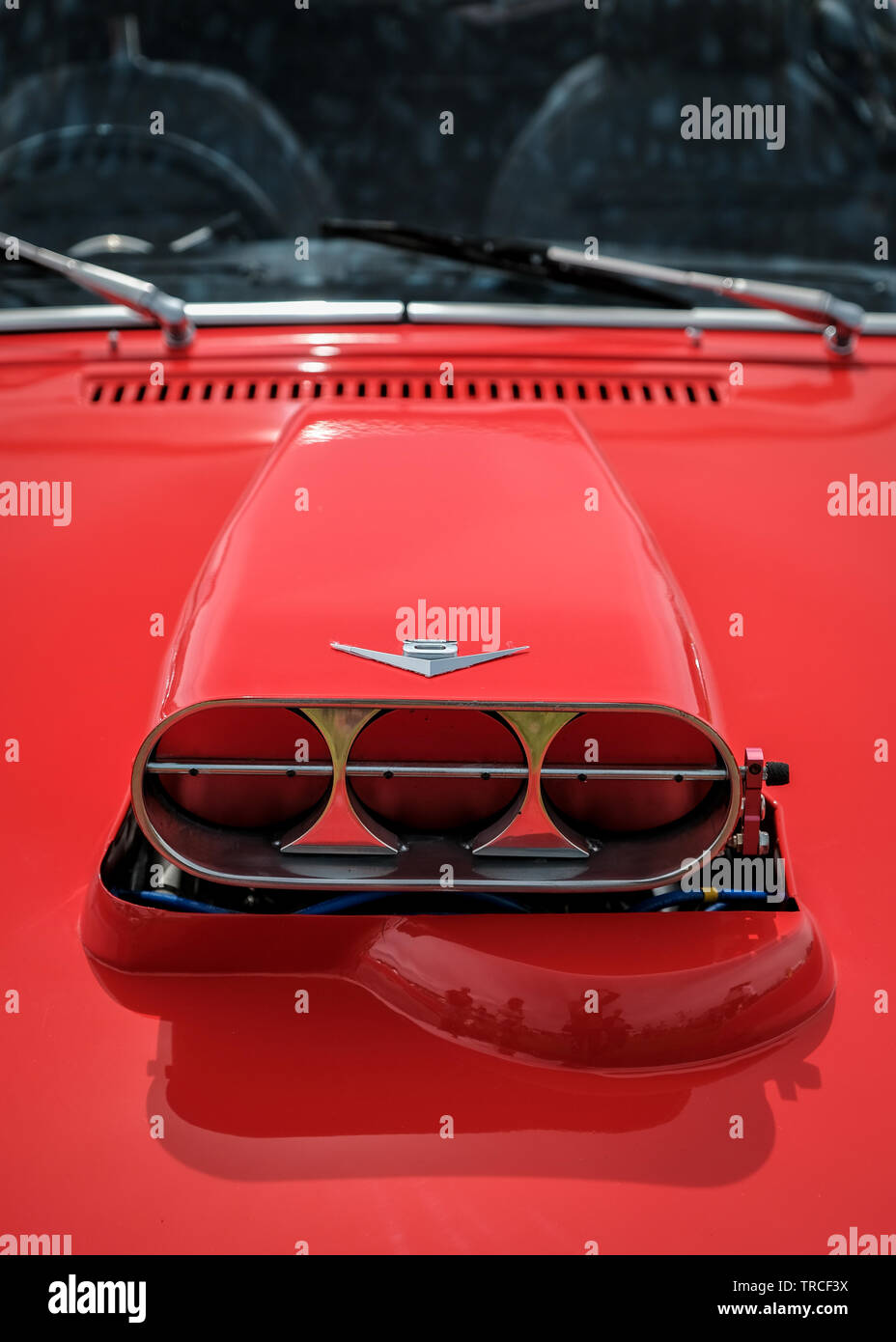 A supercharger intake on the bonnet of a vintage red Triumph Spitfire sports car Stock Photo