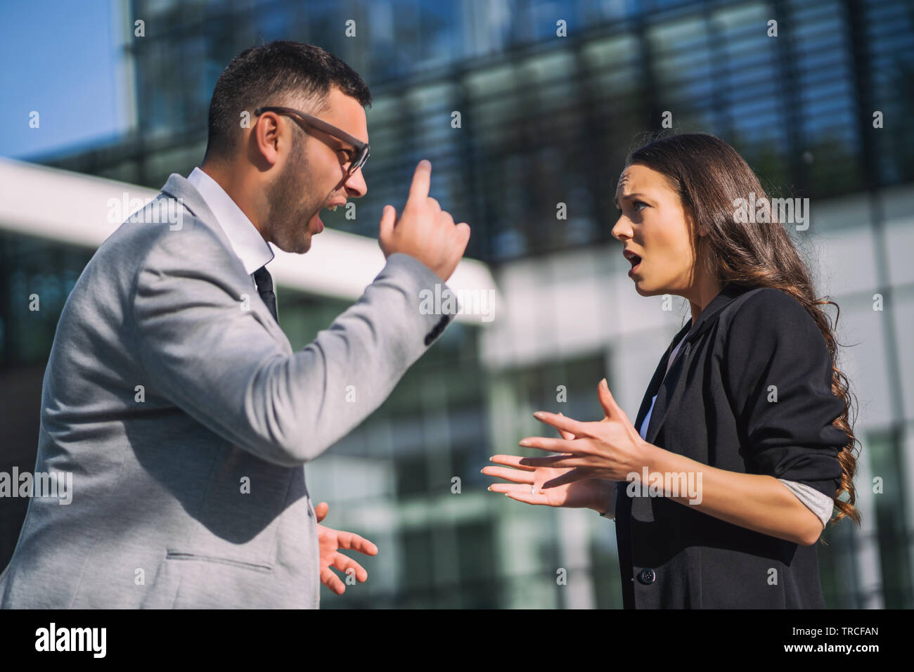 Business colleagues are arguing outside the company building. Stock Photo