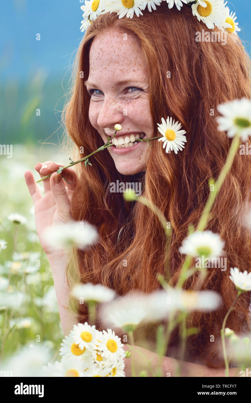 Beautiful Red Haired Girl With Freckles And A Camomile In A Mouth A