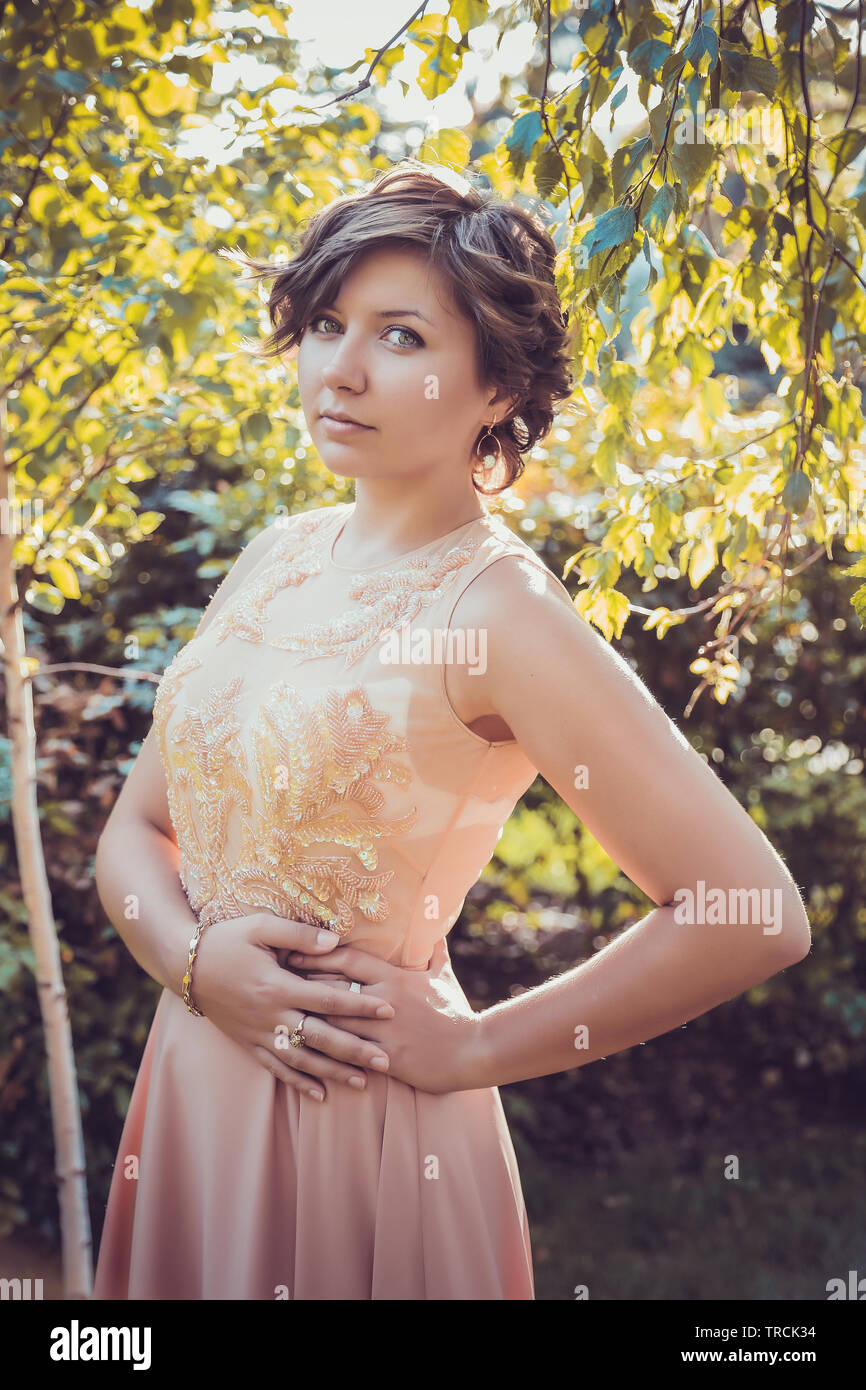 Beautiful city woman has walking on a street. Girl in evening dress and  styling short hair Stock Photo - Alamy