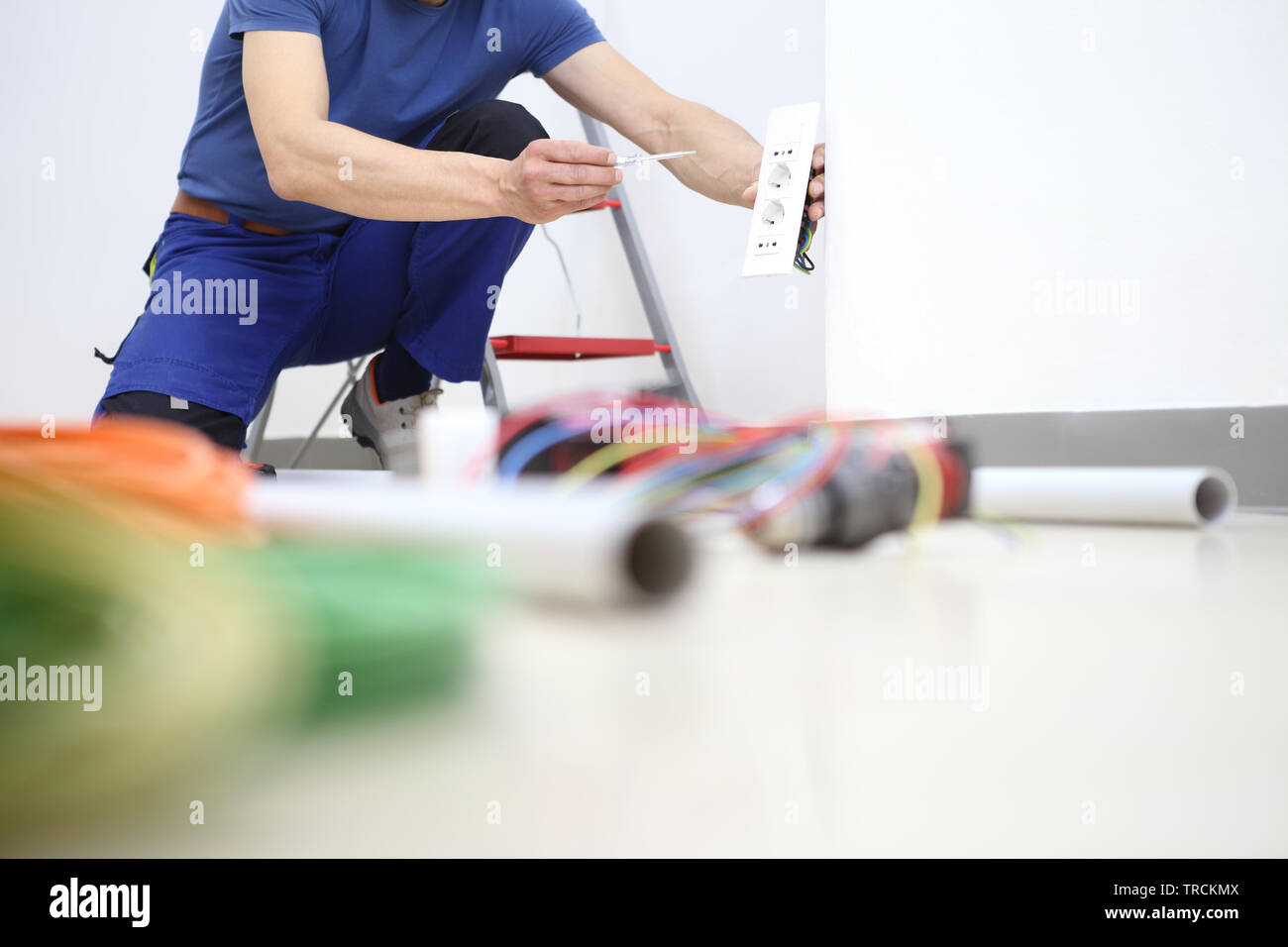 electrician at work with screwdriver in hand connects the cables to the