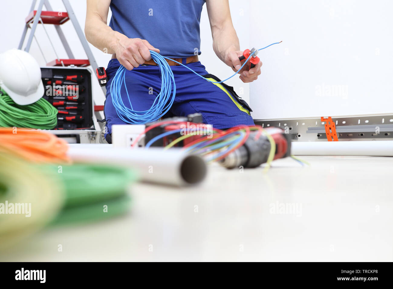 electrician at work with nippers in hand cut the electric cable ...