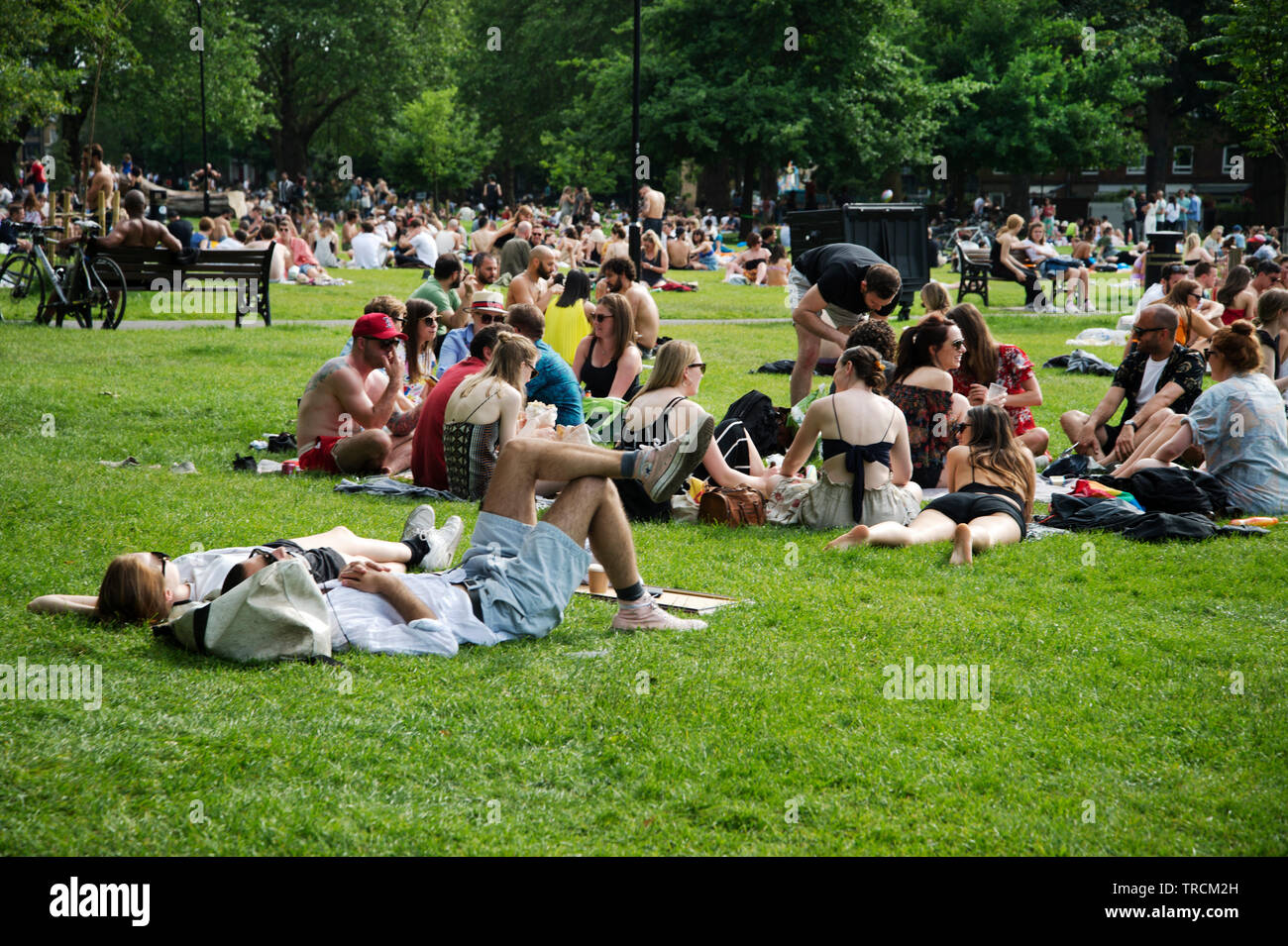 London Hackney London Fields Visitors Sunbathe On A Hot Saturday Afternoon Stock Photo Alamy