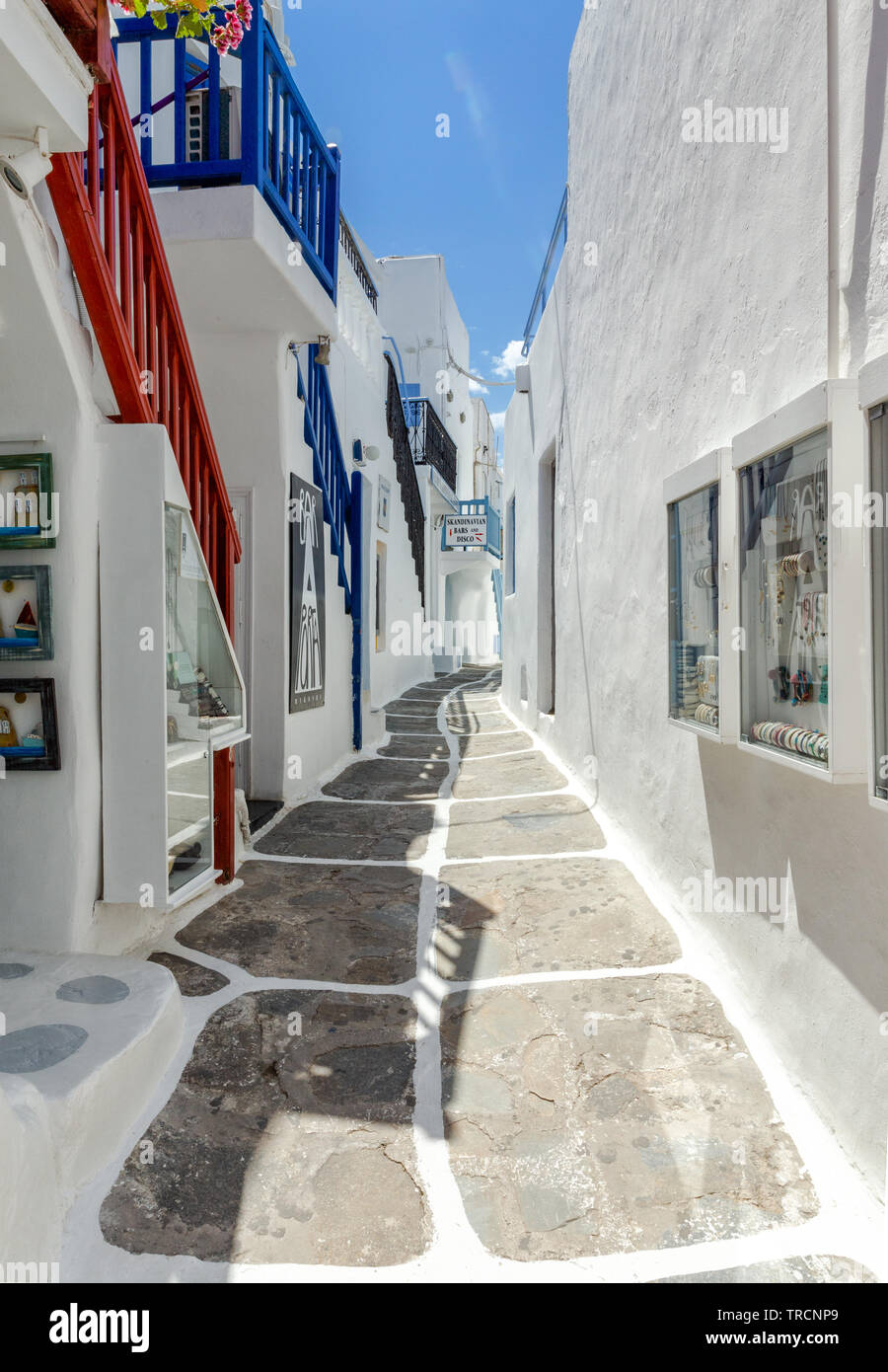 Narrow alley in Mykonos Town with colorful railings, lined with large ...