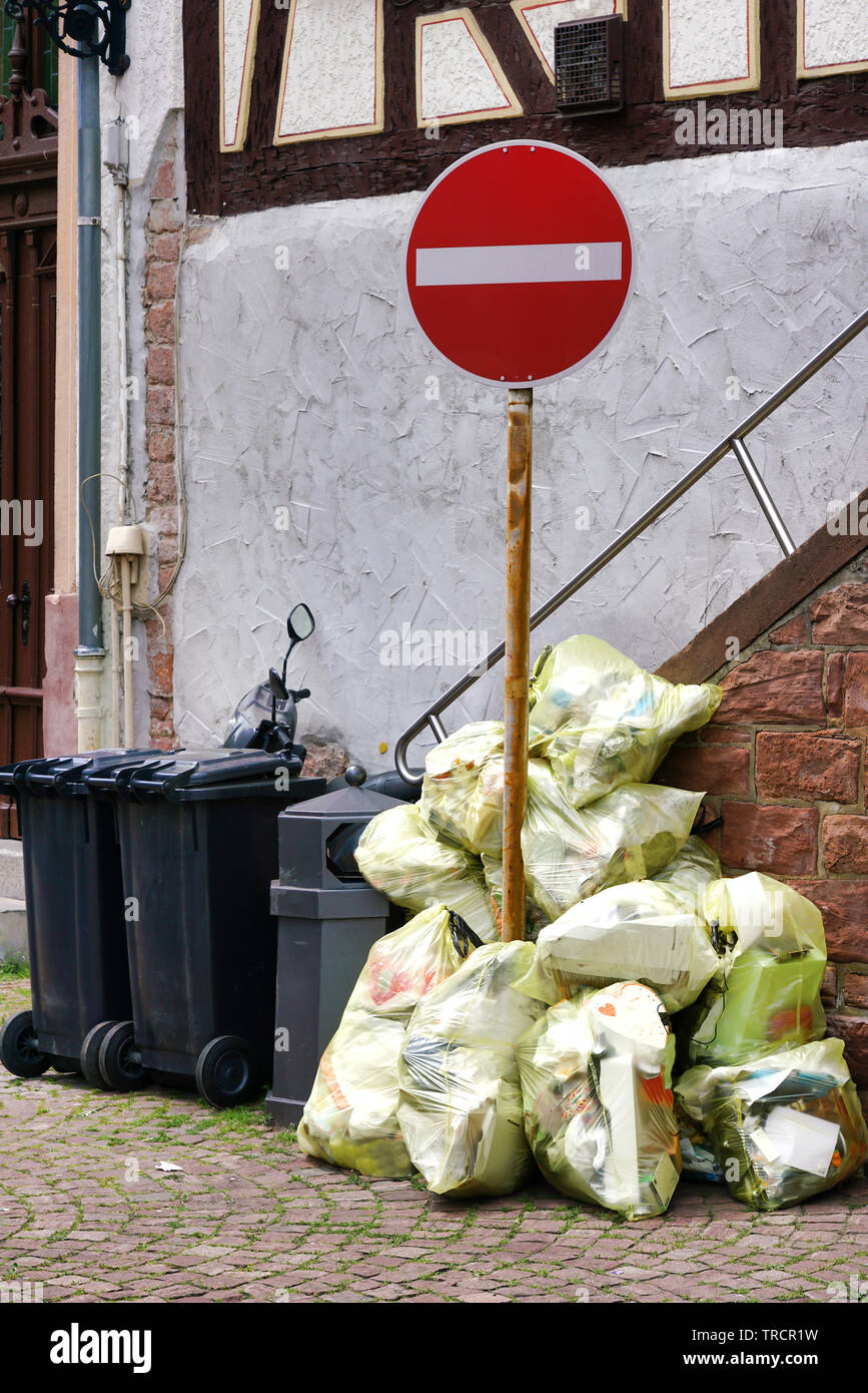Yellow garbage bags and bins stand in front of a house. Dual system in Germany Stock Photo