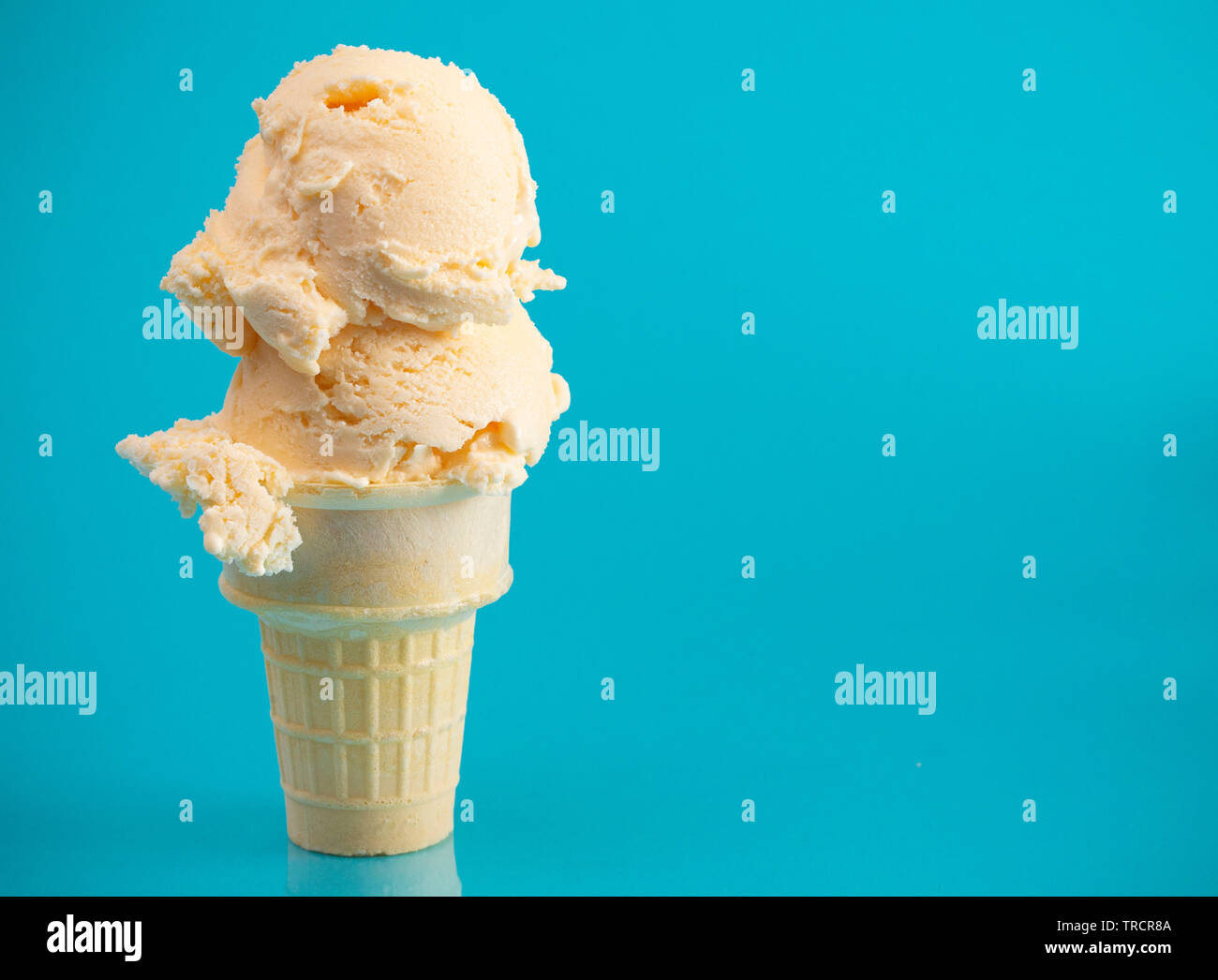 Double Scoop Vanilla Ice Cream Cone on a Blue Background Stock Photo ...
