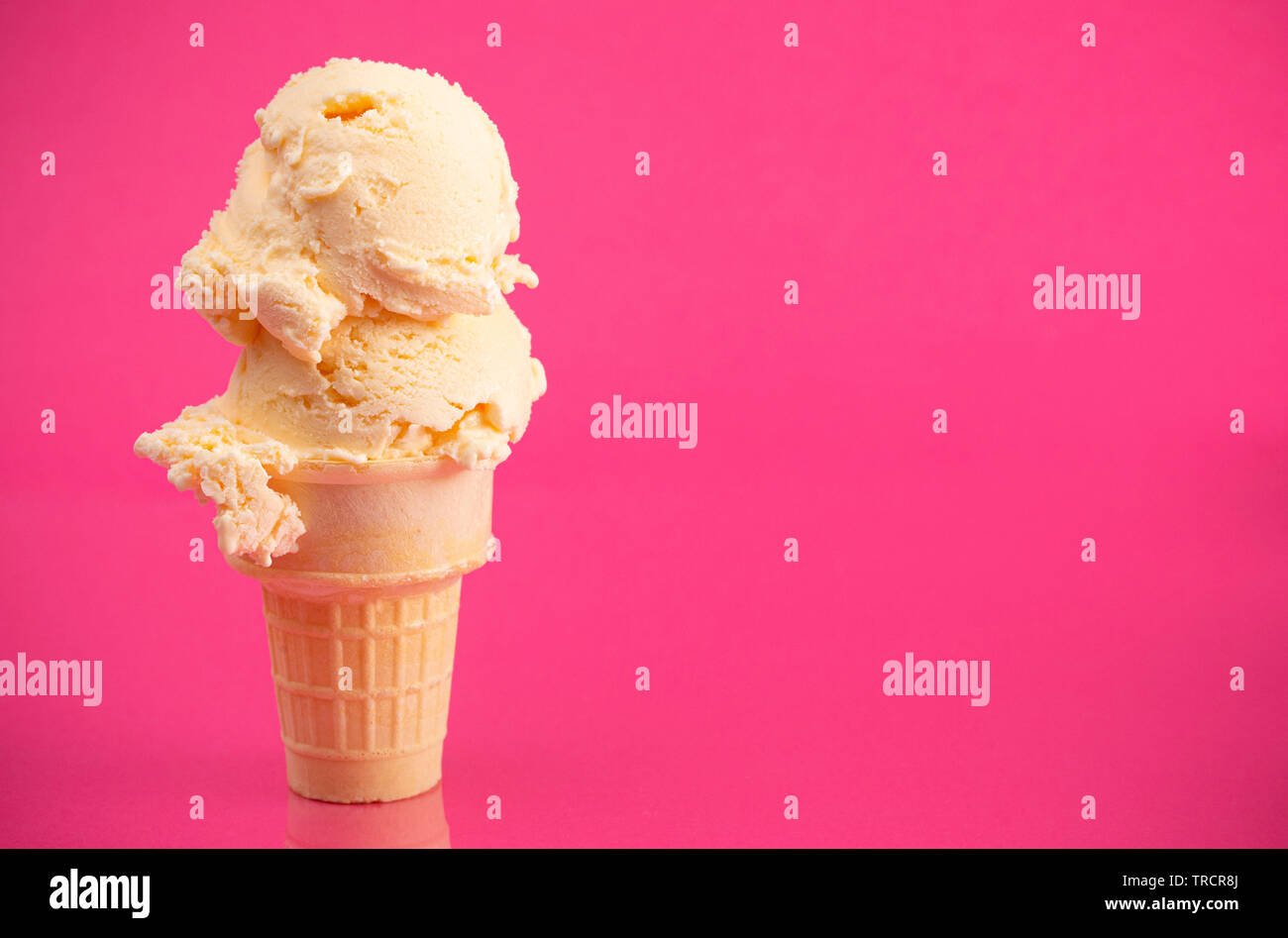 Double Scoop Vanilla Ice Cream Cone on a Bright Pink Background Stock