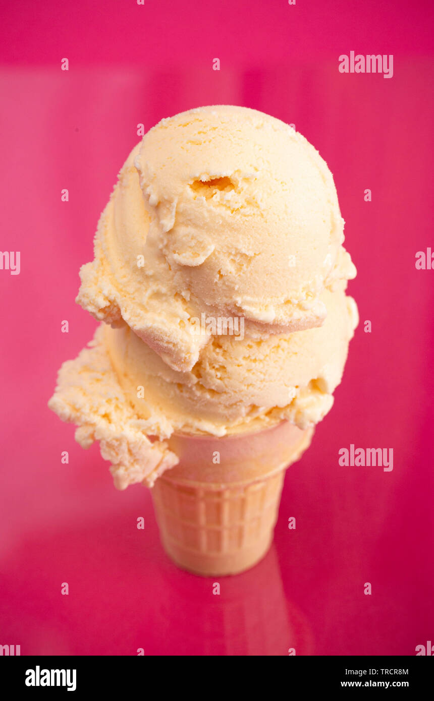 Double Scoop Vanilla Ice Cream Cone on a Bright Pink Background Stock