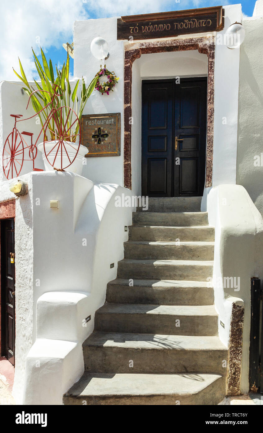 Unique front entrance to a restaurant in Oia, Santorini, Greece showing a  bicycle painted red and brick lined doorway Stock Photo - Alamy