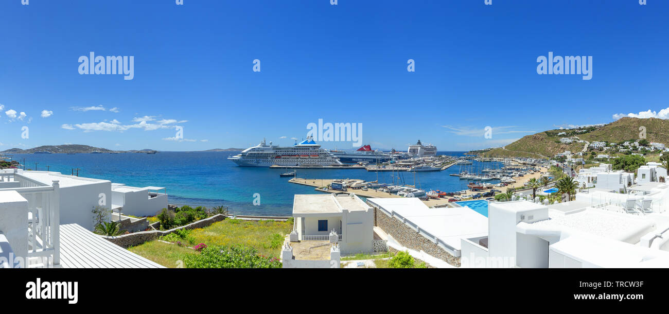 Mykonos, Greece - May 8, 2019: Panorama of a Celestyal Cruises ship and Hellenic Seaways ferry unloading and loading passengers in Mykonos Greece. Stock Photo