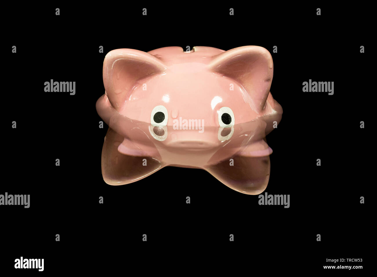 Vintage piggy bank toy up to its eyeballs in deep dark water. Stock Photo