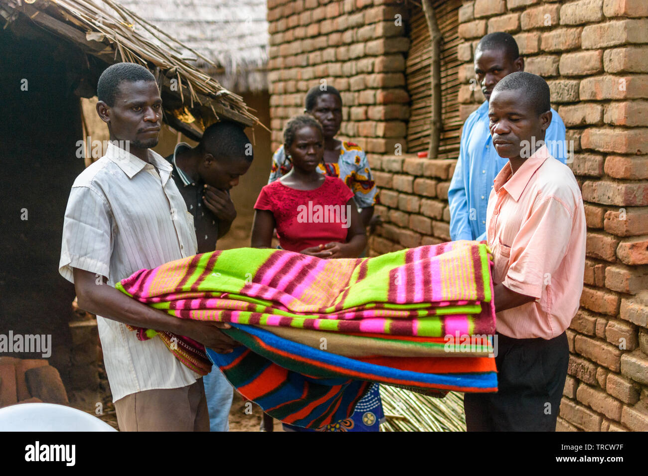 men carry blankets donated to help the victims of cyclone Idai in Malawi Stock Photo