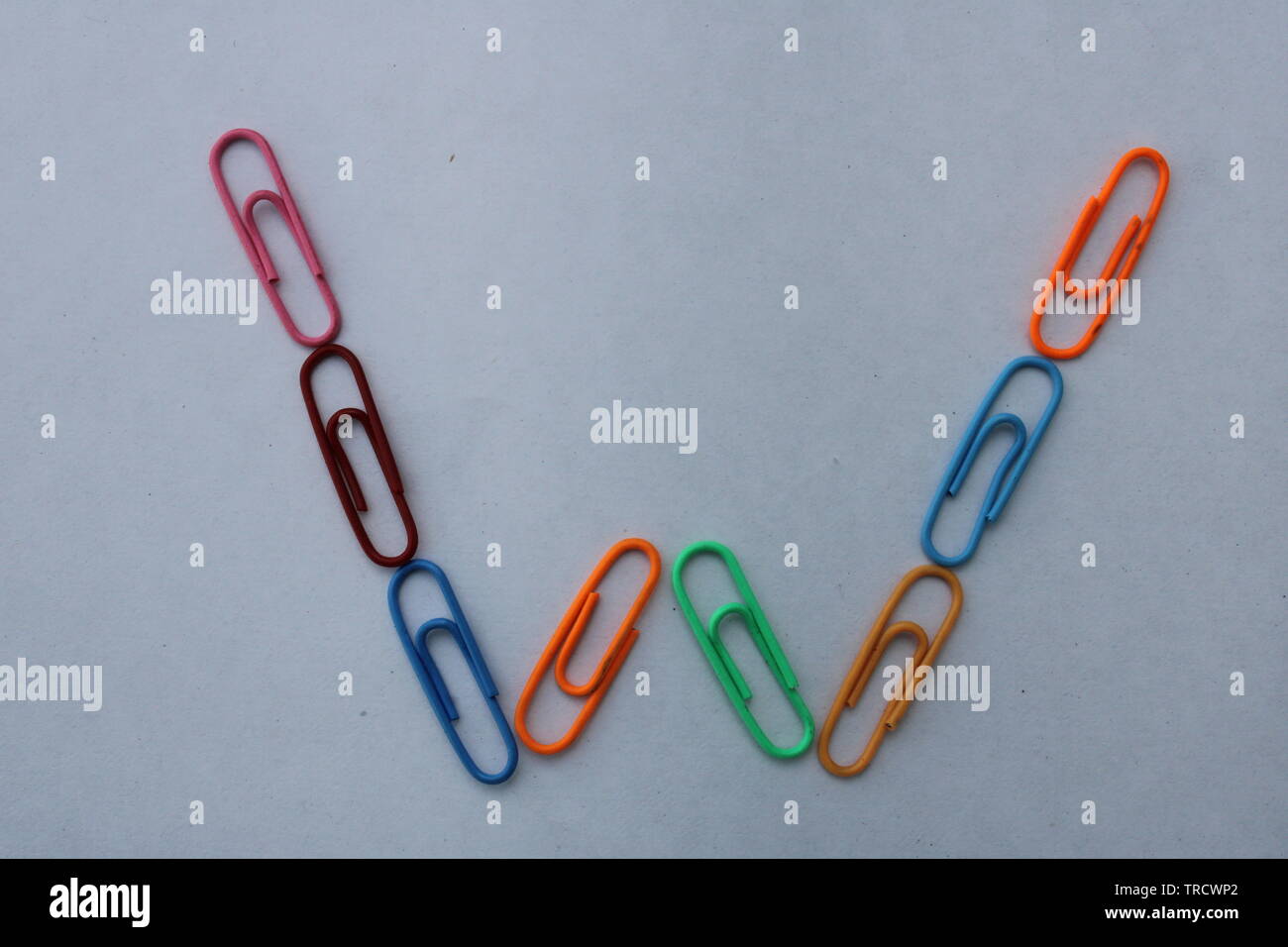 Letter W made with colorful paper clips on white background Stock Photo