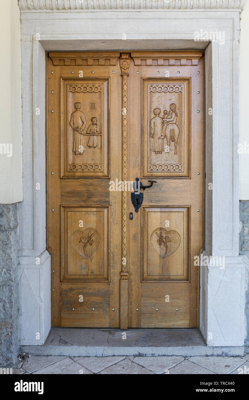 Carved wooden church door at the pilgrimage Church of Our Lady of Consolation in Log pri Vipavi, Slovenia Stock Photo