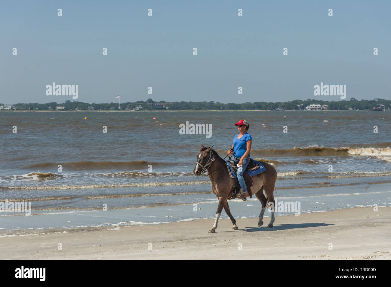 Girl horseback riding on the shoreline of Jekyll Island, USA