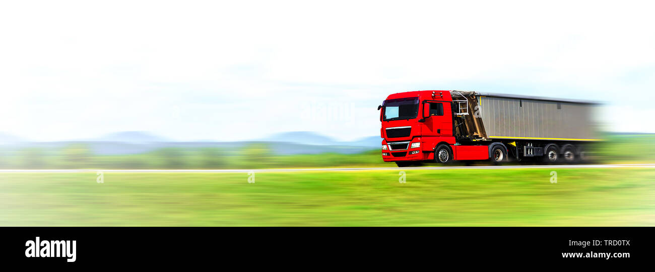 Transportation industry banner. Modern red generic truck with load moving fast on the highway - motion blur effect (copy space) Stock Photo