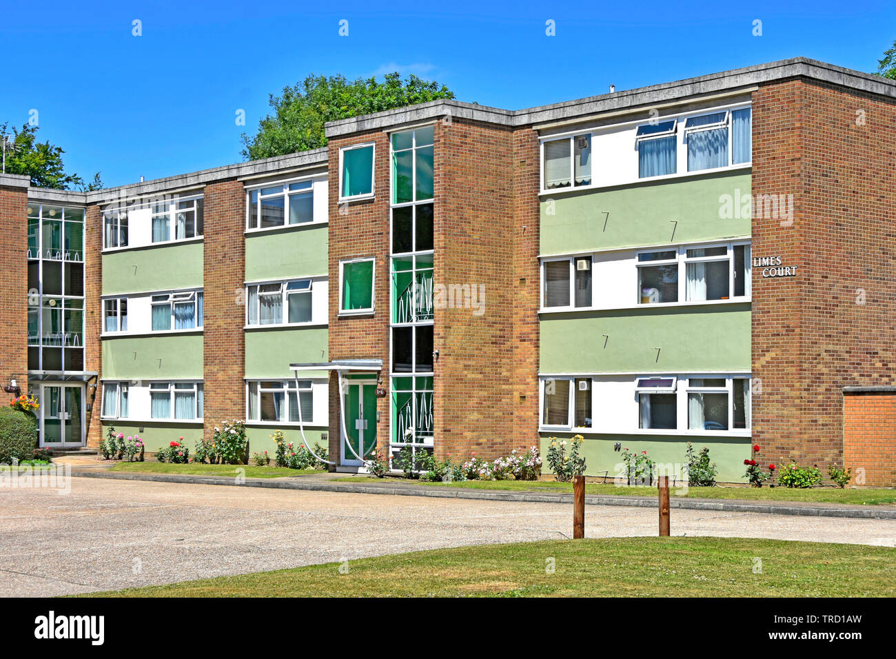 Exterior small block of flat type apartment homes brickwork housing property with window infill panels & central entrance staircase Essex England UK Stock Photo