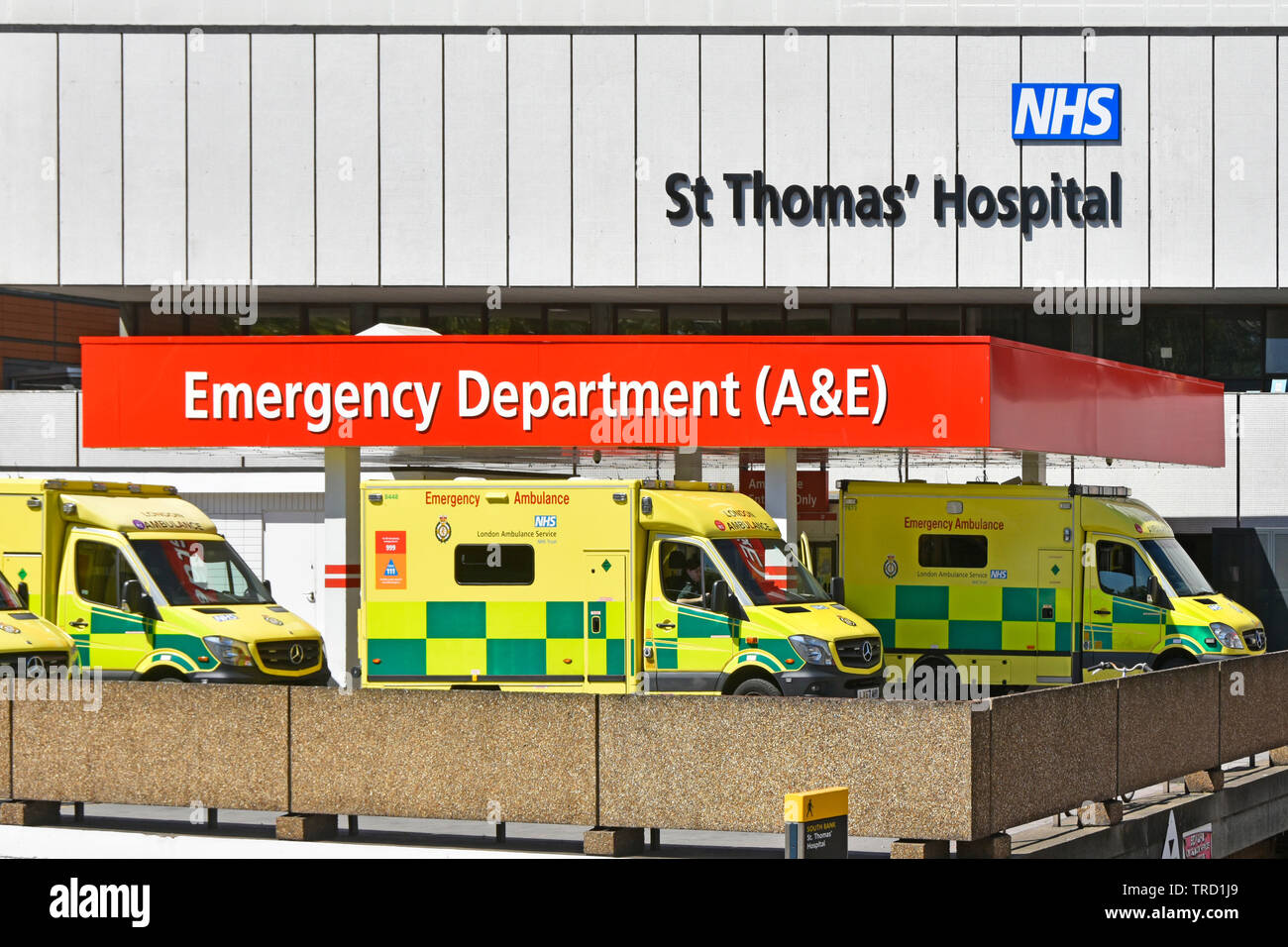 London ambulance service vehicles at St Thomas NHS hospital building A&E accident emergency healthcare department waiting at drop off area Lambeth UK Stock Photo