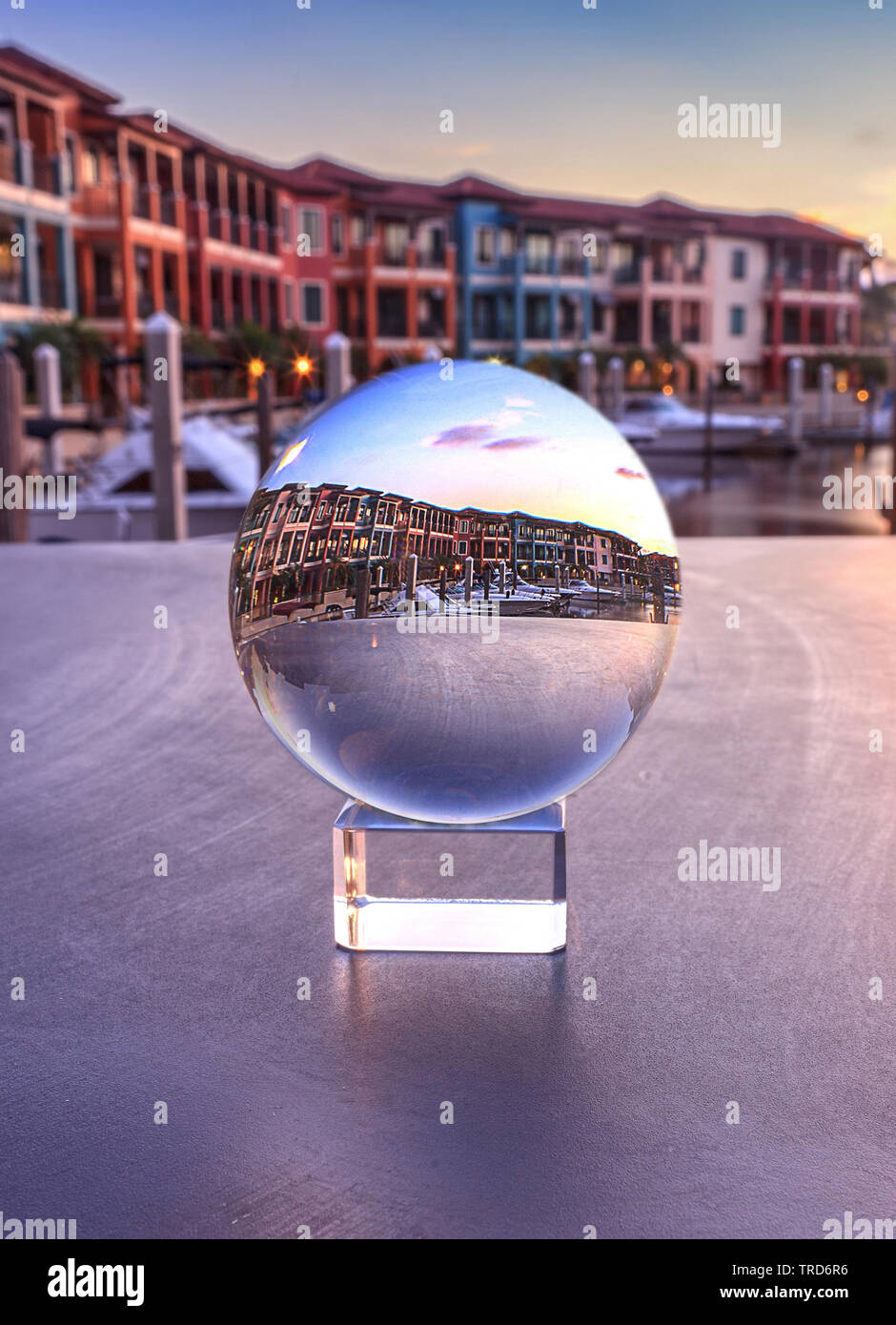 Naples, Florida, USA – May 29, 2019: Crystal ball with colorful buildings and a harbor of boats along a waterway in Naples, Florida inside. Stock Photo