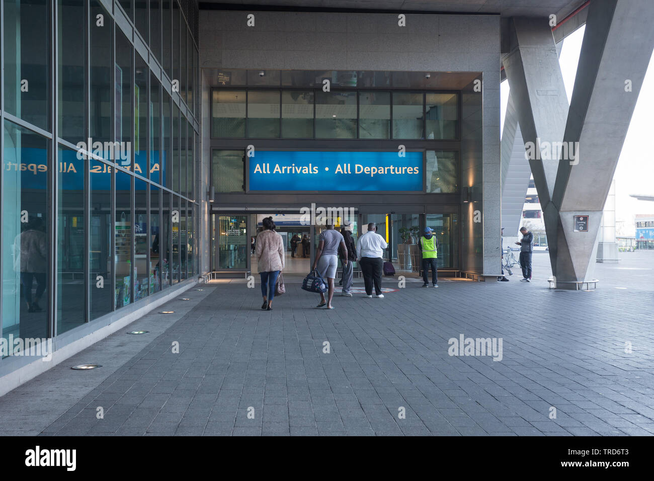 passengers, tourists, people making their way to the entrance of the arrival and departure